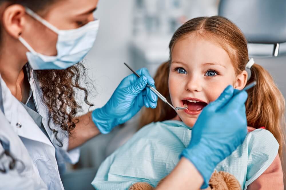 A Tony Hill Dental dentist checking the little girl teeth