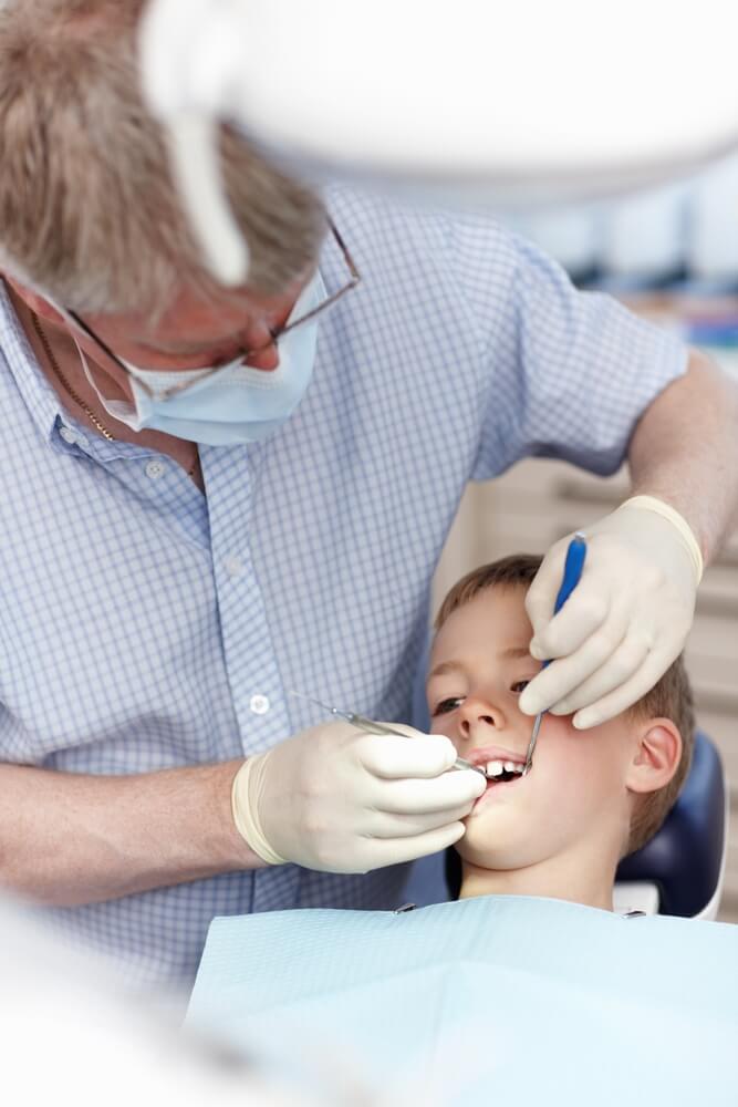 A Tony Hill Dental dentist checking the boy teeth